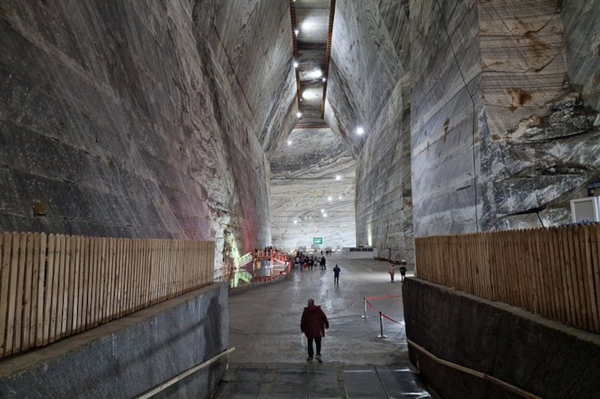 Un vaste espace intérieur, semblable à une caverne, avec de hauts plafonds et des murs constitués de grandes dalles de pierre. 3