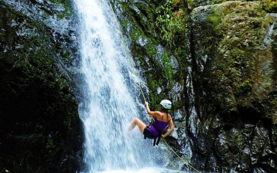 A person rappelling down a waterfall. 4