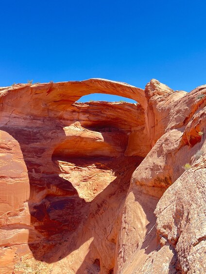 A natural rock arch formation in a desert landscape. 1