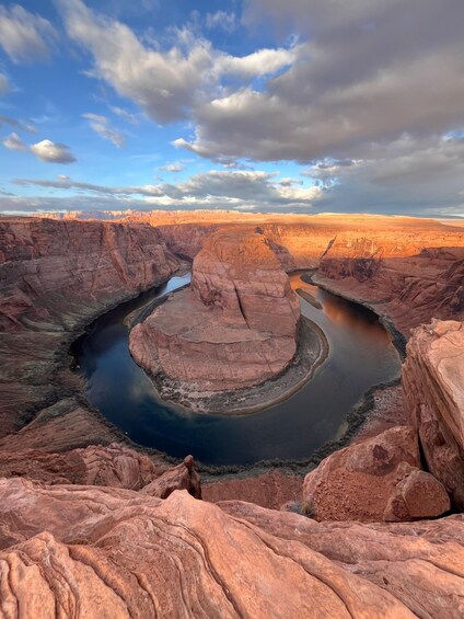 A canyon with a river winding through it, surrounded by reddish rock formations. 3