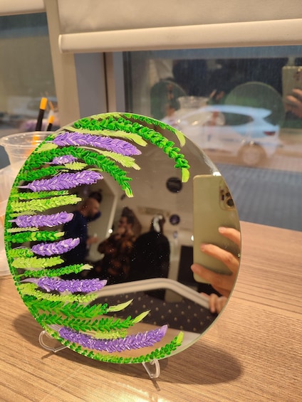 A decorative glass sphere with green and purple floral patterns. 5