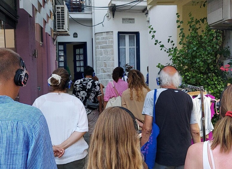 A group of people walking down a narrow street with buildings on either side. 4