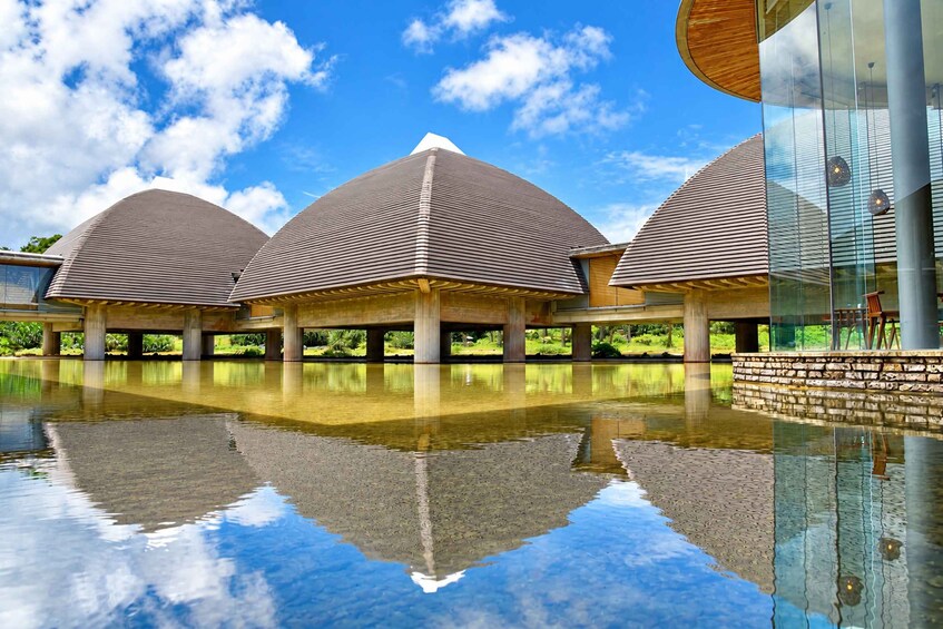 A modern architectural structure with a reflective pool in front. 4