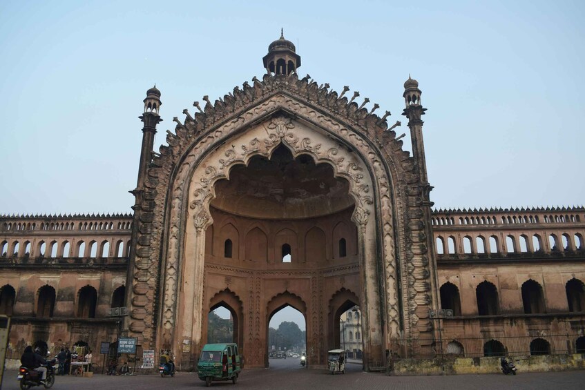 An ornate historical archway with intricate carvings and a domed structure above. 4