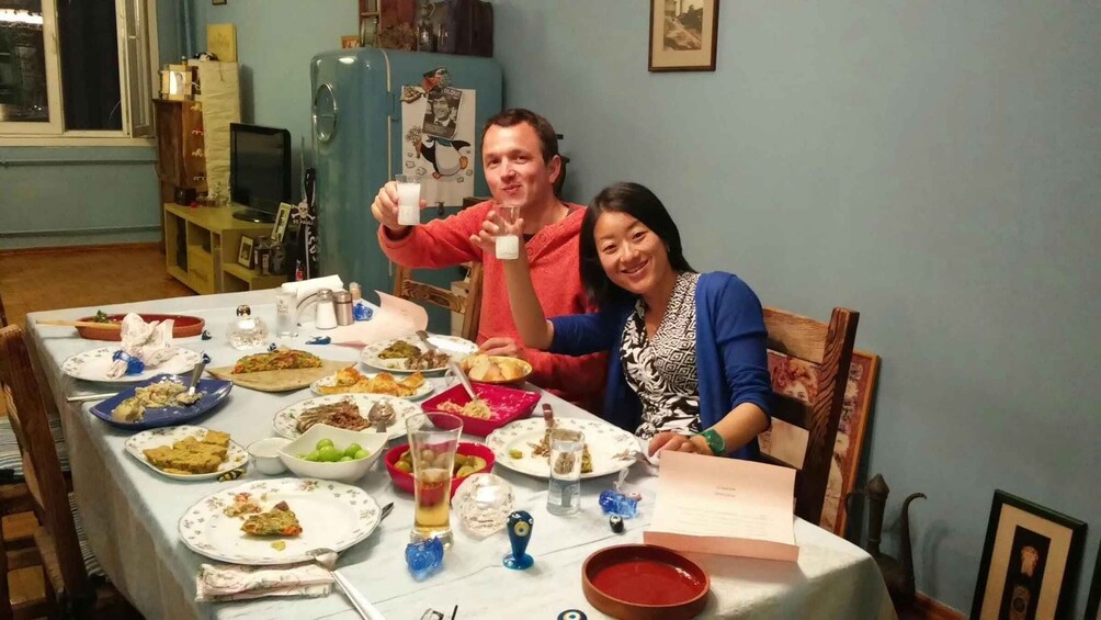 A dining table with various dishes, a blue refrigerator, and a vintage radio in a room with blue walls. 4