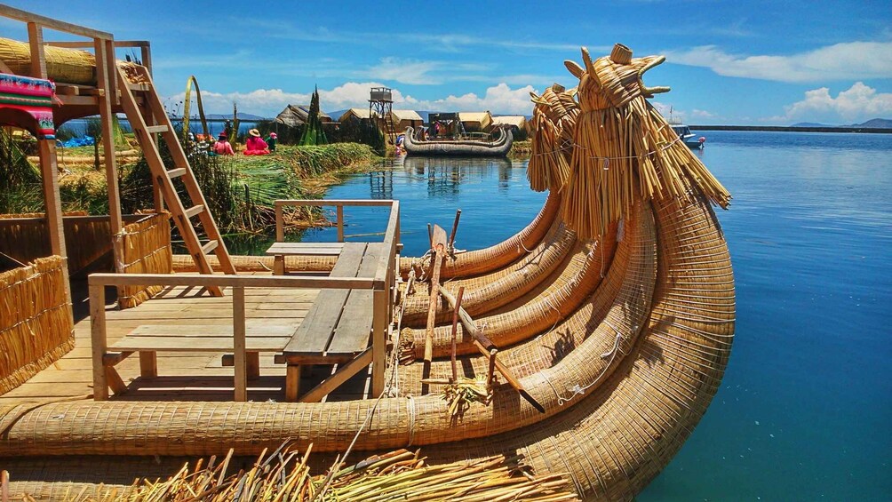 A traditional boat made of woven reeds docked at a wooden pier. 2