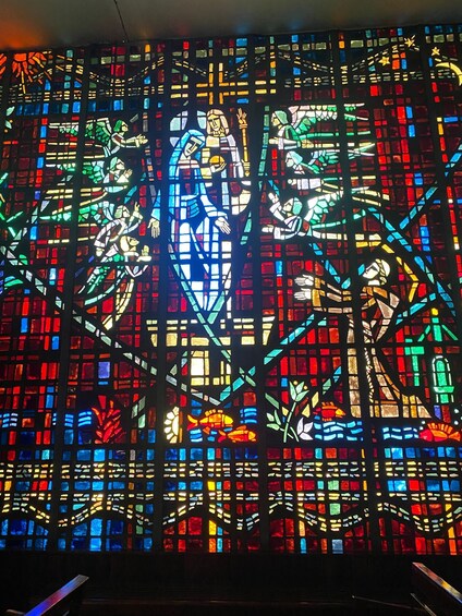 A stained glass window with geometric patterns and figures. 5