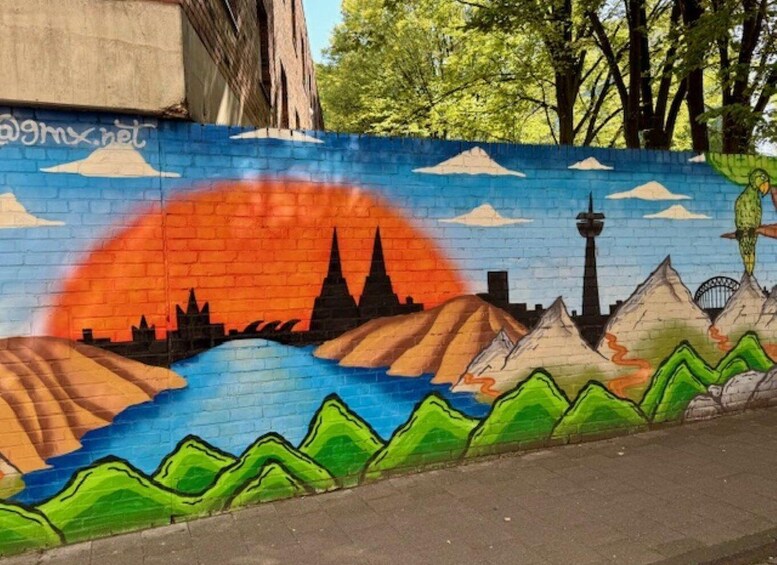 A mural with a sunset, mountains, a city skyline, and a bird. 4