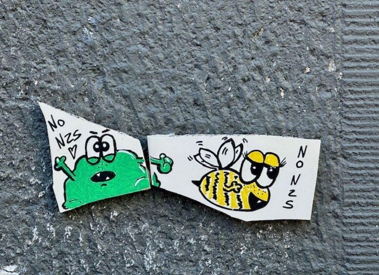 A drawing of a green monster and a bee on a textured surface. 5