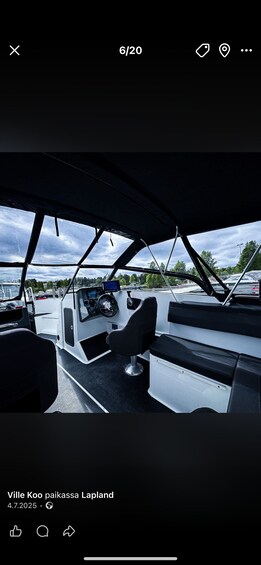 The interior of a boat with a steering wheel, seats, and a view of the water outside. 5