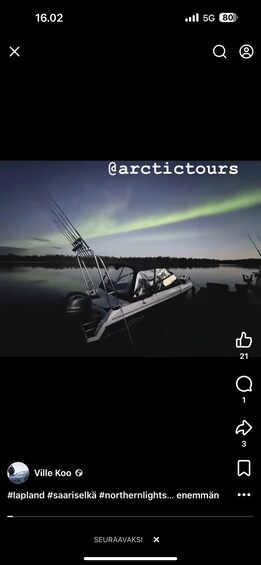 A boat docked at a pier with the Northern Lights in the background. 4