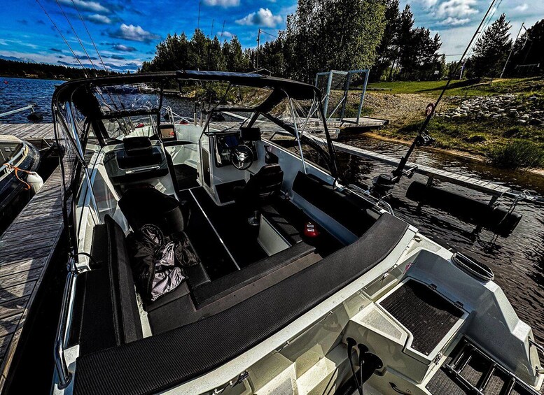 A boat docked at a pier with a clear sky and trees in the background. 2