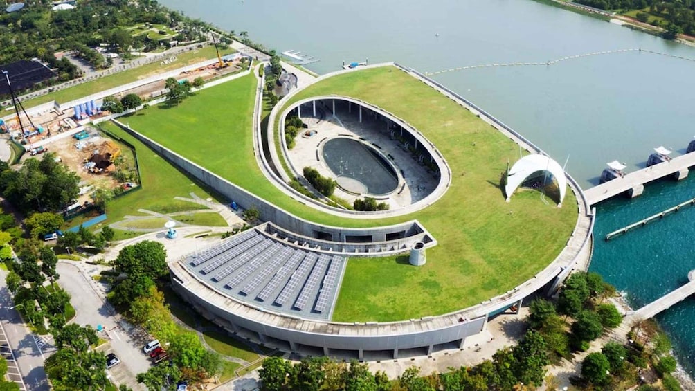 A large circular building with a central courtyard, surrounded by a body of water and greenery. 5