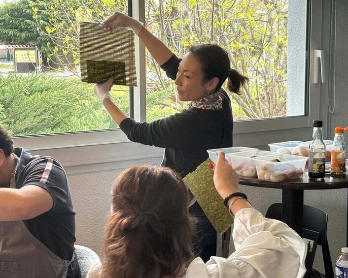 A person holding a woven basket near a window with greenery outside. 5