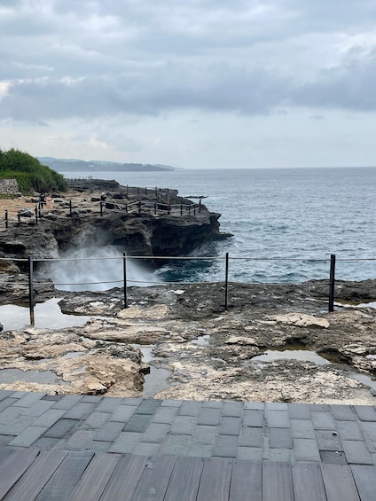 A rocky coastline with a wooden walkway leading to a viewing platform. 1