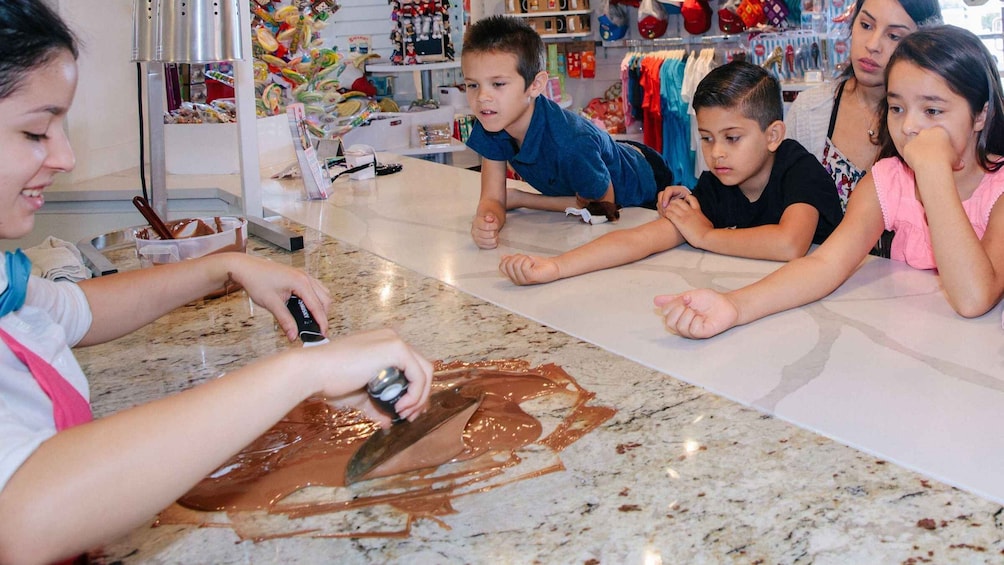 Children and an adult at a table with a chocolate spread. 2