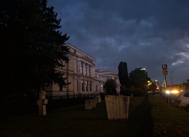 A historic building at dusk with a parking sign nearby. 3