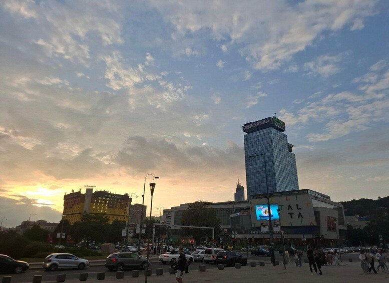 A busy urban street with a prominent ASIA BANKA building, a hotel, and various shops. 2