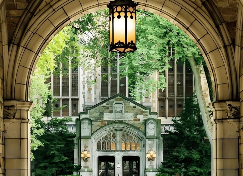 An arched entrance with a lantern, gothic arches, and a building with large windows in the background. 2