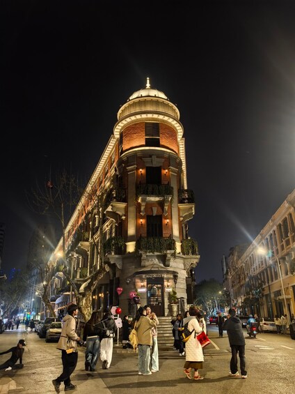 A historic building with a dome and ornate architecture, surrounded by a busy street at night. 2