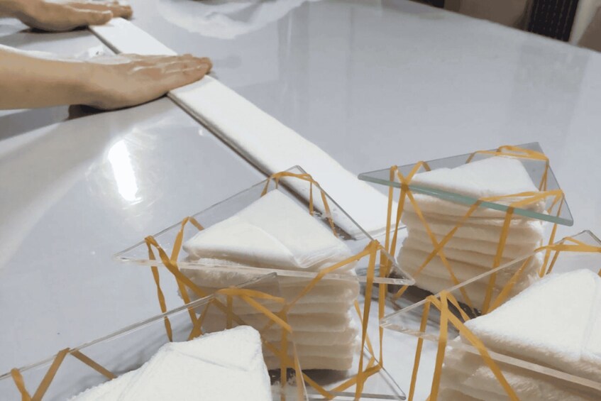 A person placing a white object on a glass display with yellow straps. 3