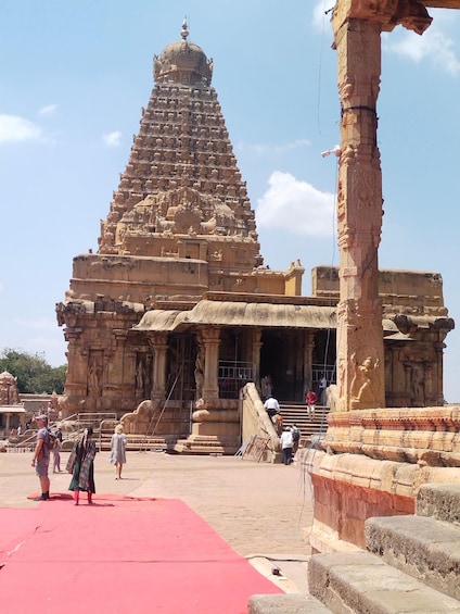 A temple with a large, ornate tower and a red carpet in the foreground. 5