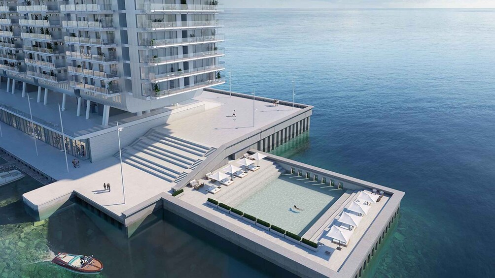 A high-rise building with a rooftop pool and a boat dock. 3