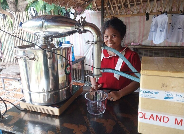 A person operating a large industrial coffee machine, a cardboard box labeled 'POLAND,' and a hanging clothesline in the background. 3