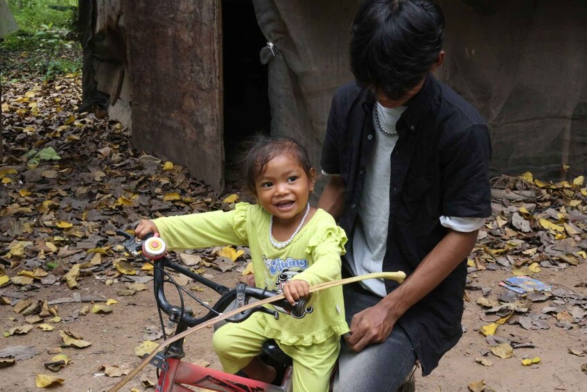 A child on a bicycle with an adult seated behind. 4