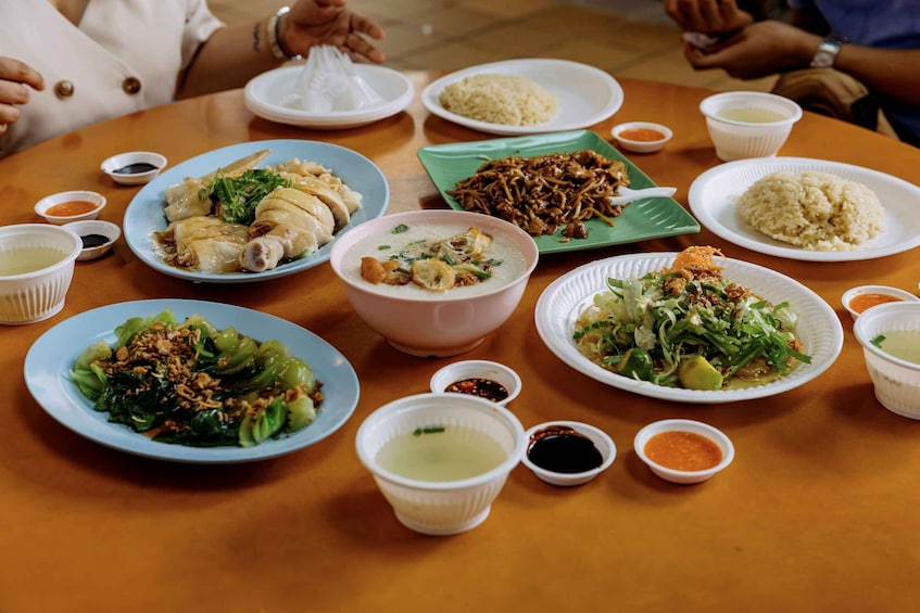 A table with various dishes including rice, vegetables, and meat, accompanied by small bowls of sauces. 2