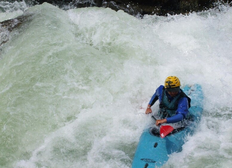 A person kayaking in a turbulent river. 4
