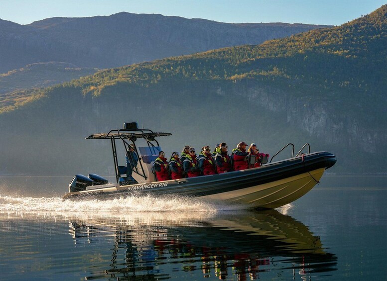 A boat with people wearing life jackets on a calm lake with mountains in the background. 3