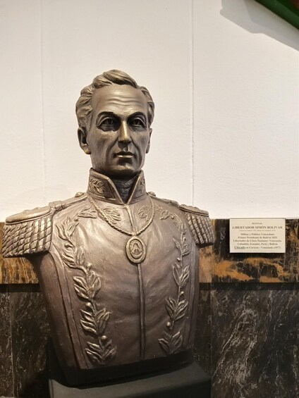A bust of a historical figure with military decorations, displayed on a marble pedestal. 3