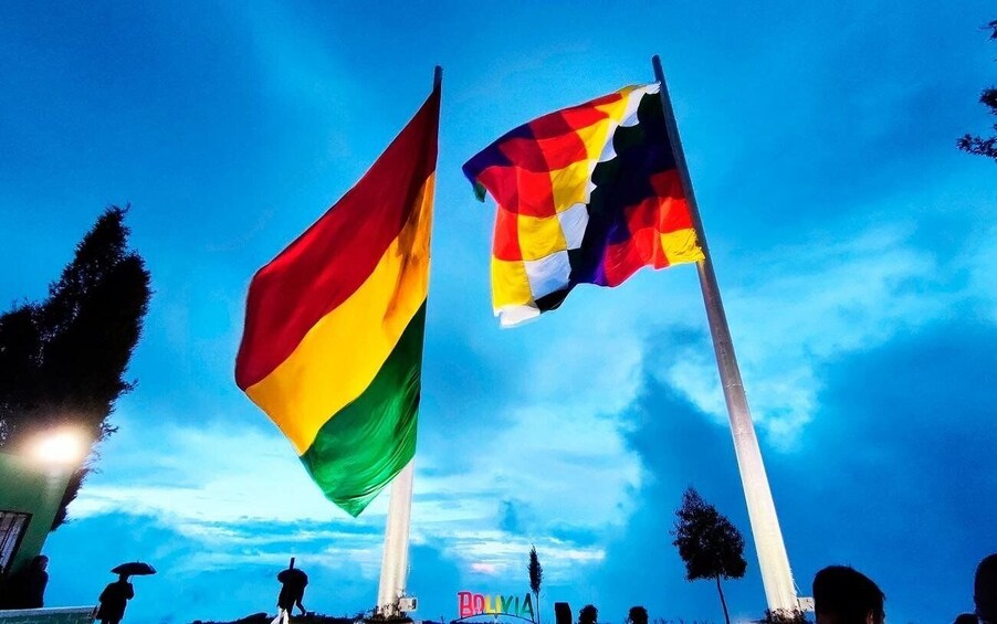 Two flags on flagpoles against a twilight sky. 4