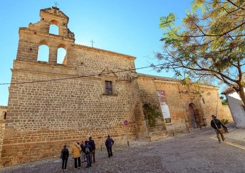 A historic stone building with arched windows and a bell tower. 5