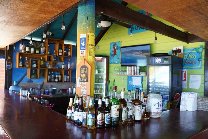 A bar with a variety of liquor bottles and a Pepsi refrigerator. 2