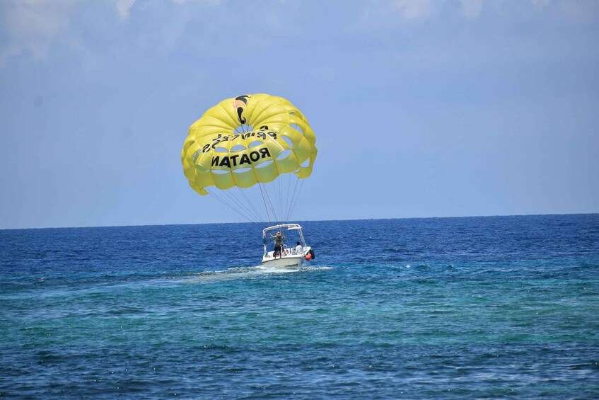 A yellow parachute with 'ROTAHA' written on it, attached to a boat on the ocean. 1