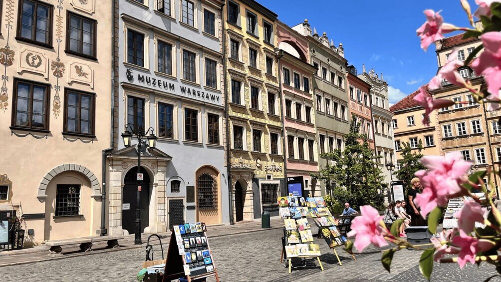 A street with a building labeled 'MUSEUM WARSAW' and a flower display. 2