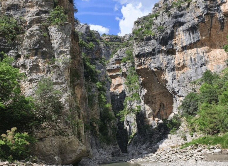 A canyon with steep rock walls and a river at its base. 5
