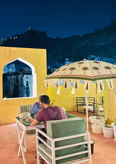 A person sitting at a table with a yellow wall and a window overlooking a mountainous landscape. 5
