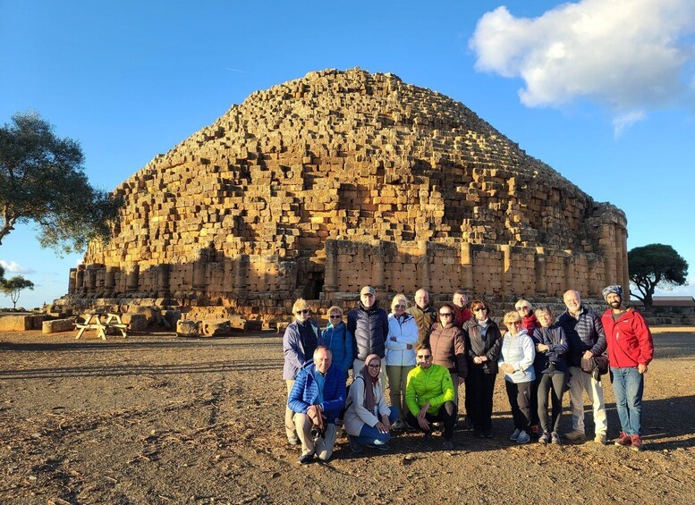 A group of people posing in front of an ancient stone structure. 5