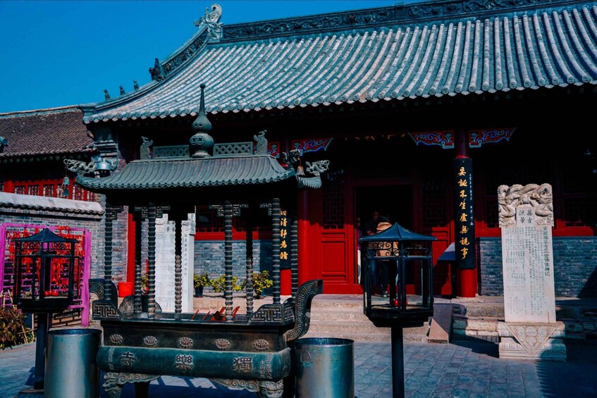 A traditional Chinese building with ornate architecture, including a tiled roof and red doors. 4