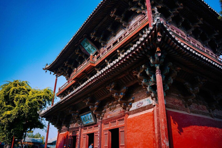 A traditional red and white building with ornate wooden architecture and a clear blue sky. 3