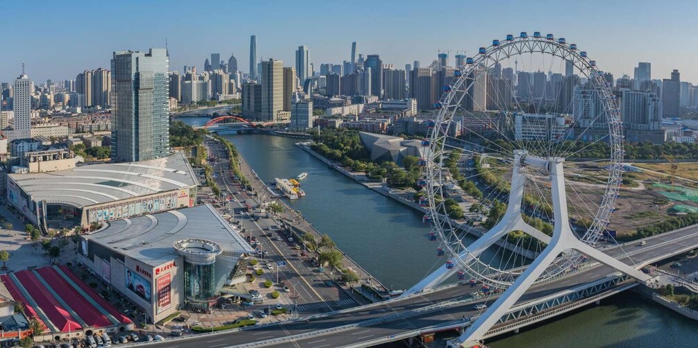A cityscape with a river, a large Ferris wheel, and modern skyscrapers. 2