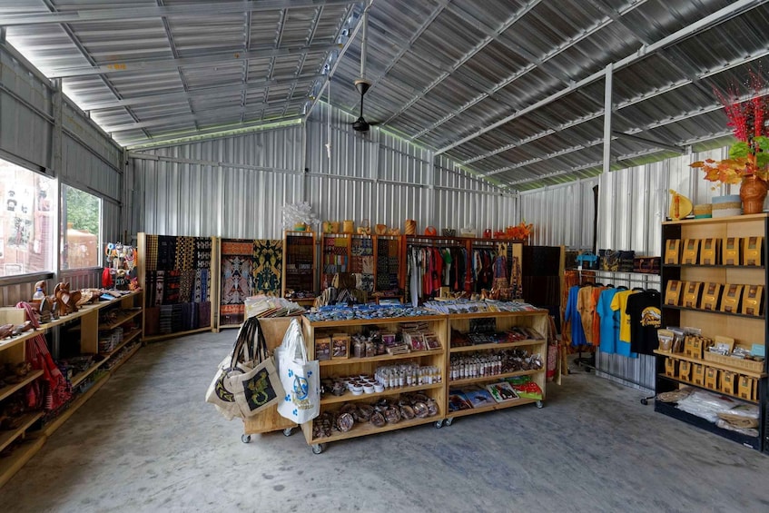 A spacious indoor market with metal walls, wooden shelves, and various items for sale. 2