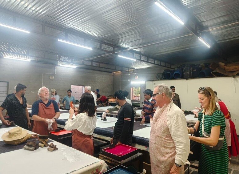 A group of people in a workshop setting, engaged in various activities. 5