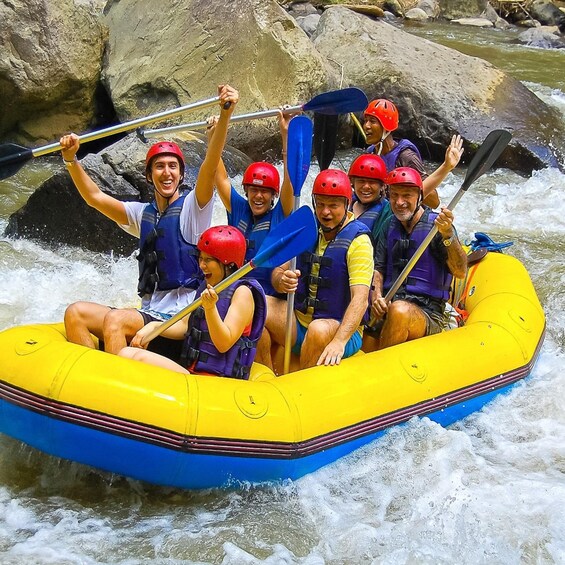 A group of people in a yellow raft navigating a river with rapids. 3