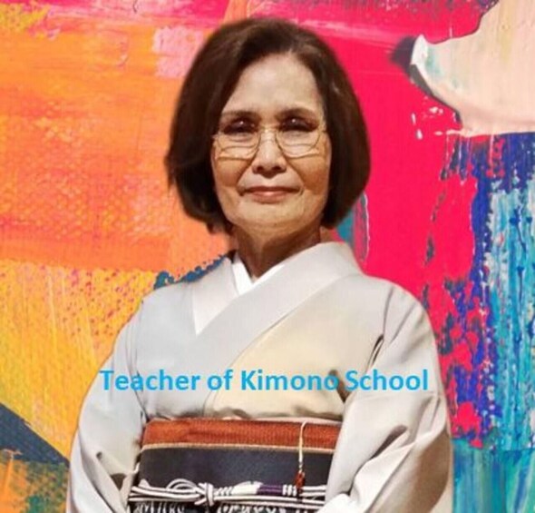 A person wearing a white garment with a striped sash, standing in front of a colorful abstract painting. 2