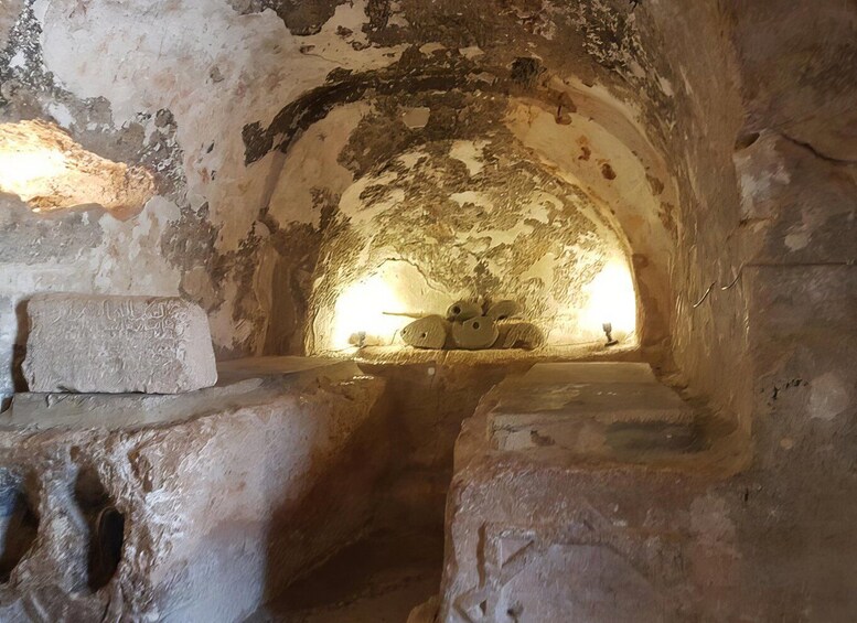 An ancient underground chamber with stone walls and a central opening. 5