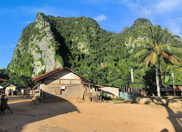 A village with traditional houses, a dirt road, and a mountain backdrop. 5